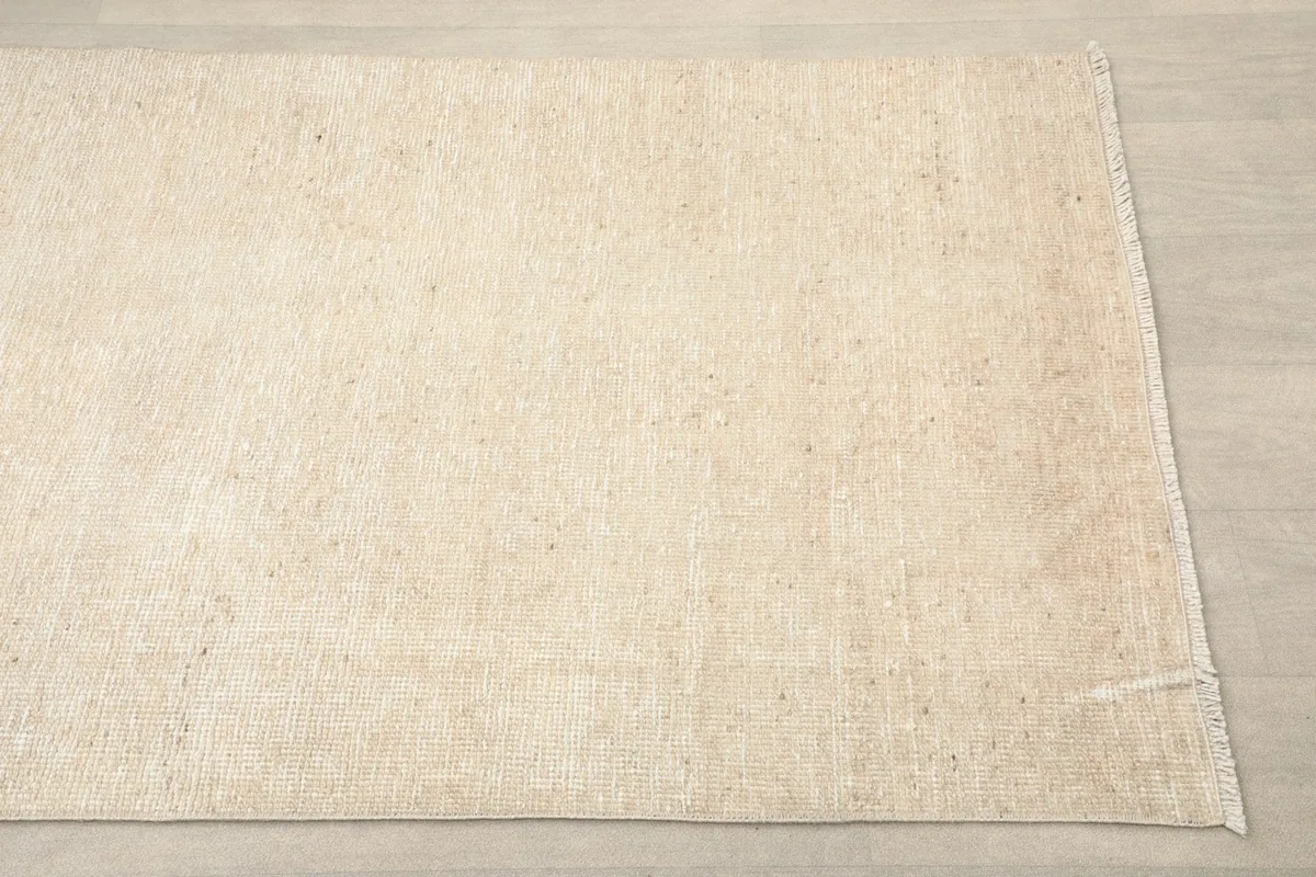 Close-up angled view of one end of the beige runner, showing its subtle texture.