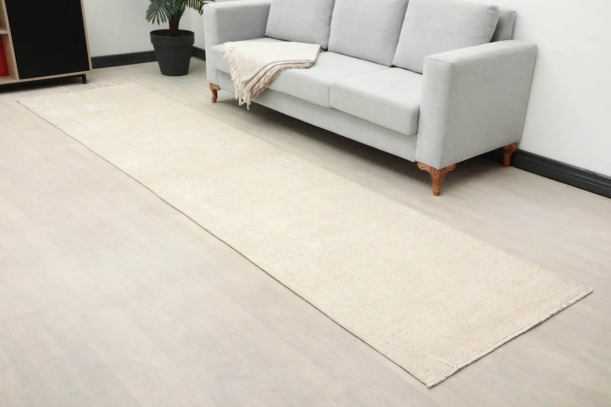 Angled view of the beige runner extending along a sofa, showcasing its length.