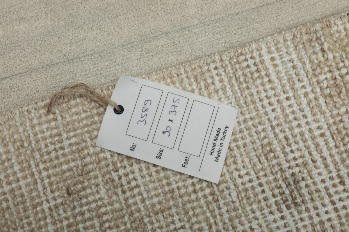 Close-up of the rug's tag on the back, showing 'Hand Made in Turkey' and size information.