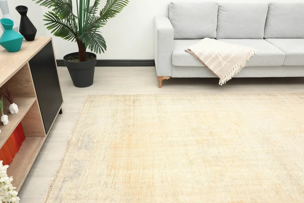 Detail view of the cream rug in a room setting, focusing on the texture and color variations