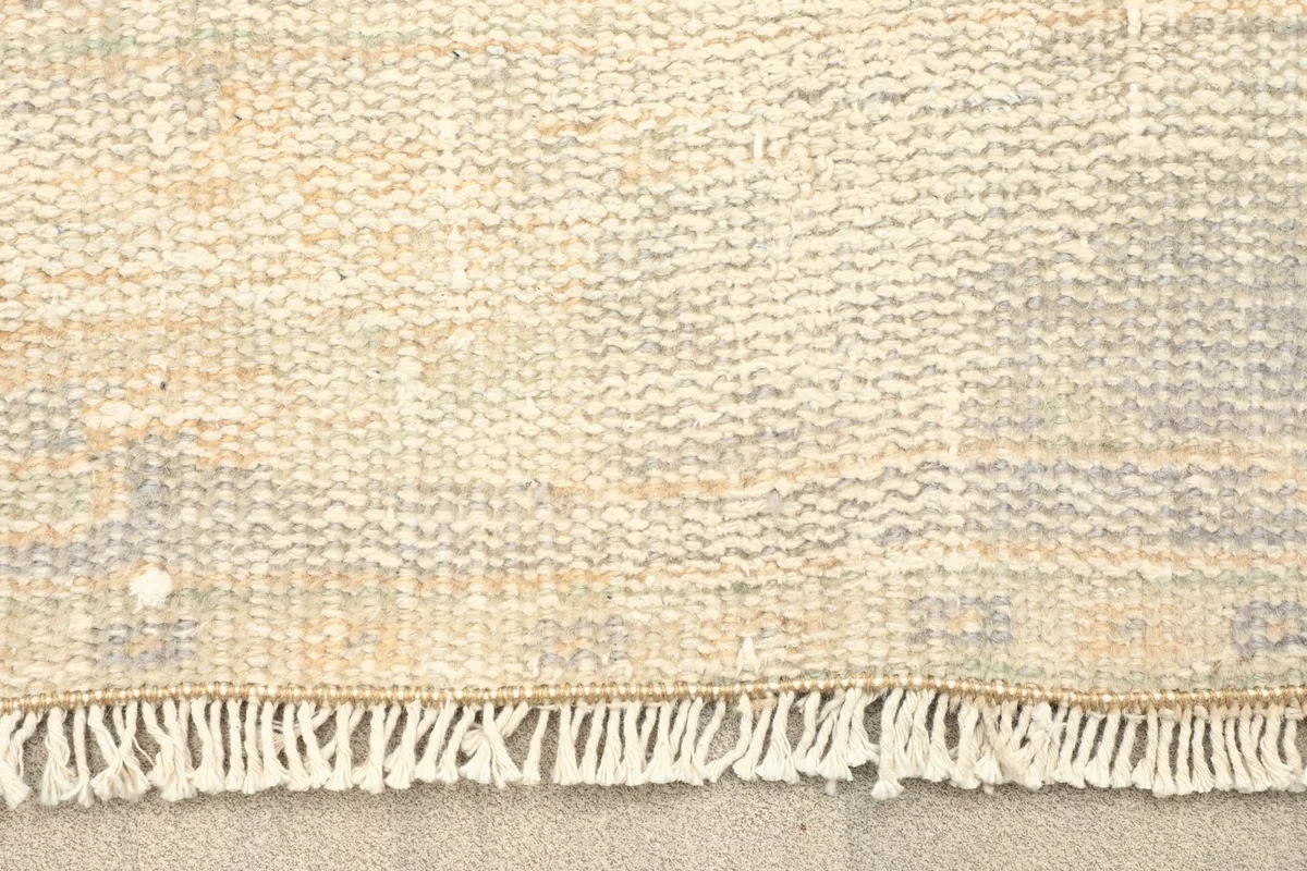 Close-up of the rug's fringe and the texture of the hand-knotted wool pile