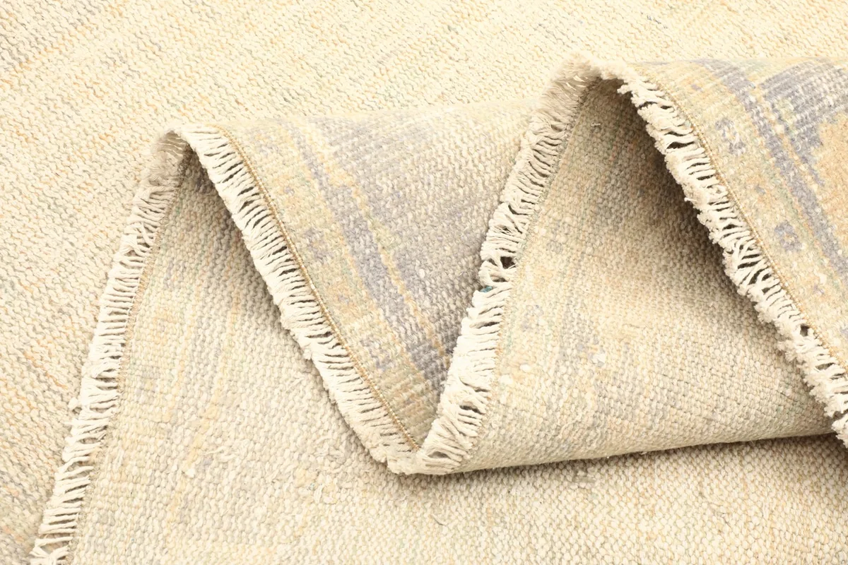 Folded edge of the rug showing its thickness and the natural variations in the wool