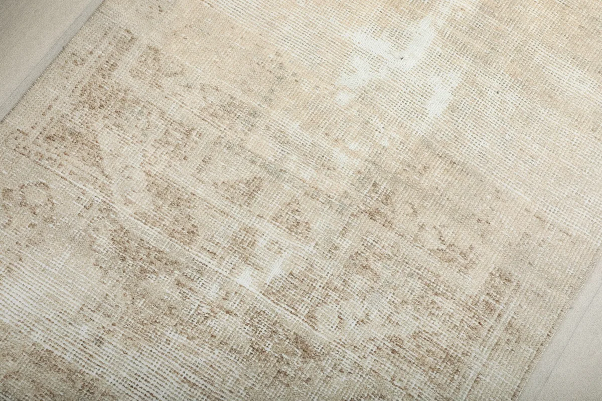 Close-up of the central geometric motif, highlighting the worn wool pile and color variations.