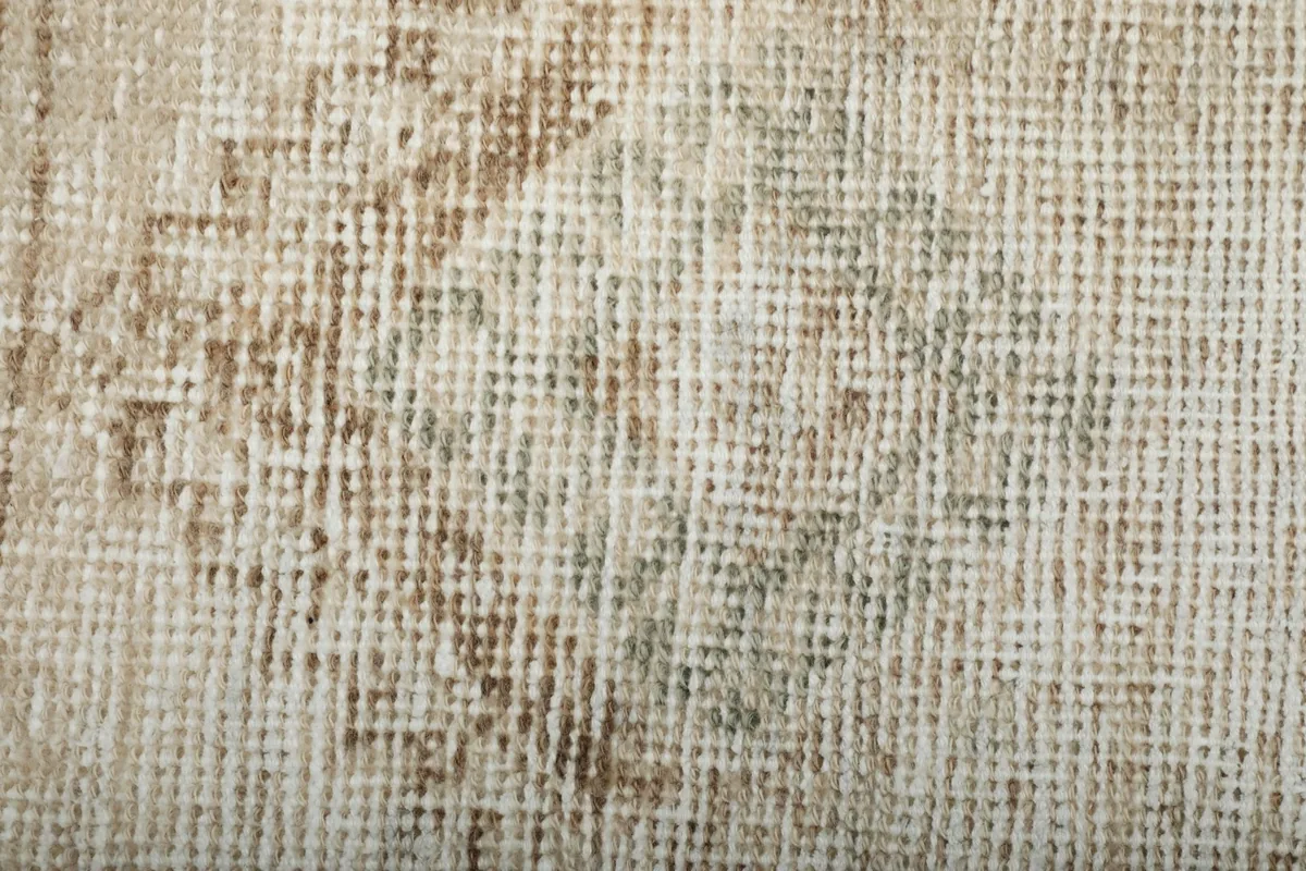 Extreme close-up of the low wool pile, showing individual knots and the distressed appearance.