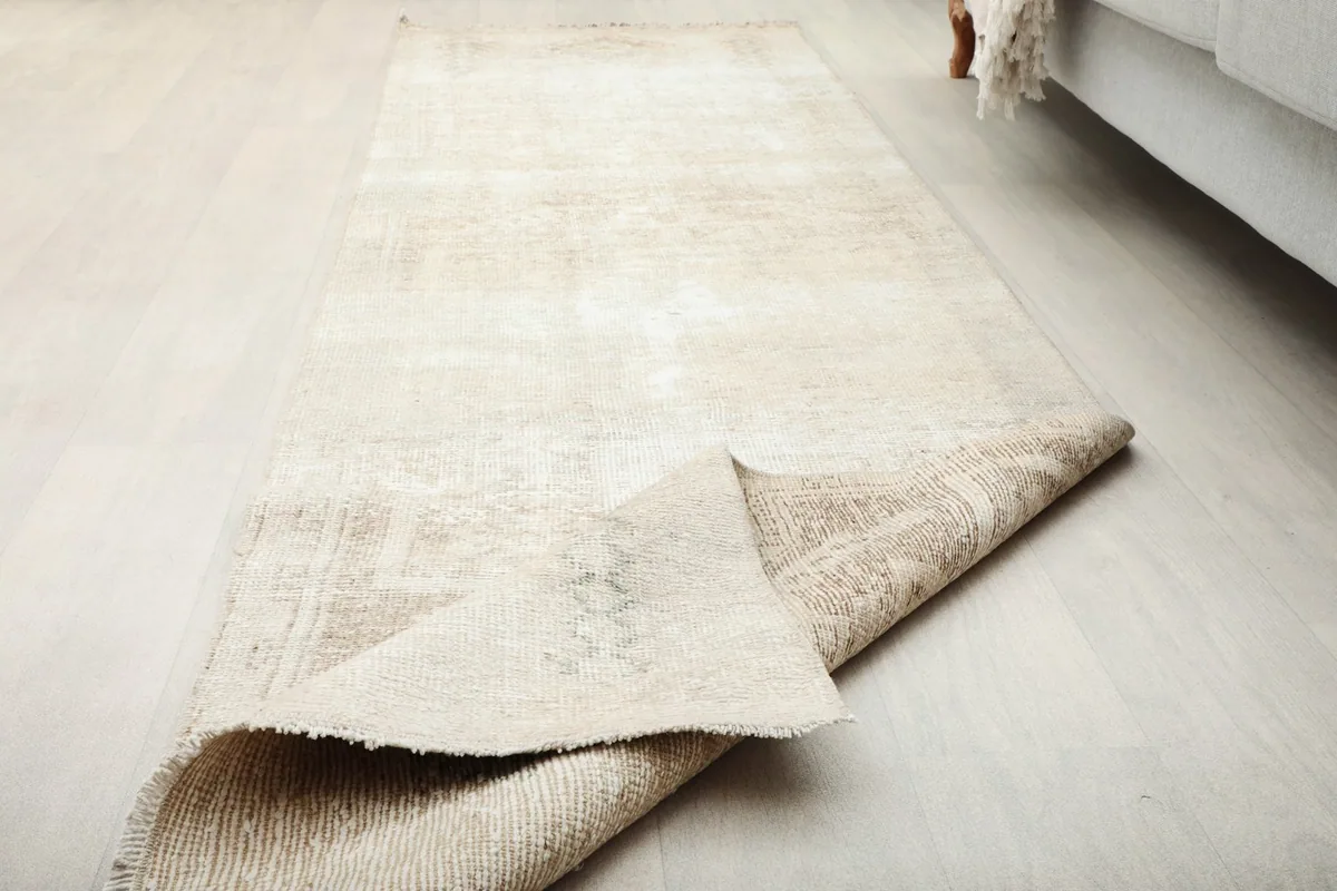 The runner rug partially folded, displaying its flexibility and the reverse side.