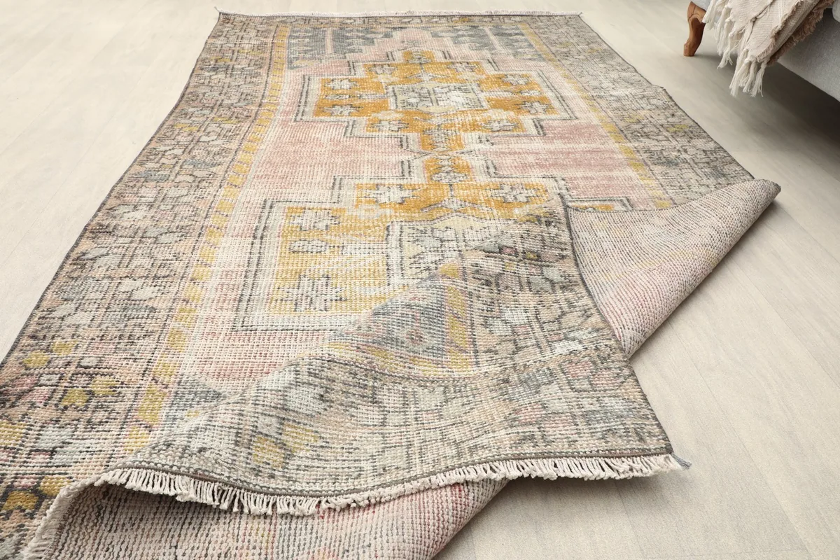 Rug partially unrolled, showcasing the full length and the texture of the wool pile and fringe.