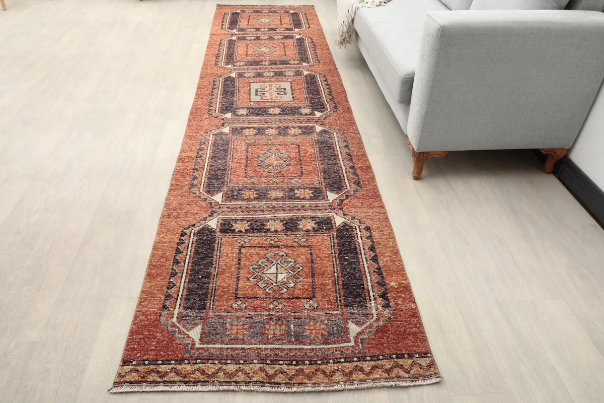 Overhead view of the runner rug extending down a room next to a sofa.