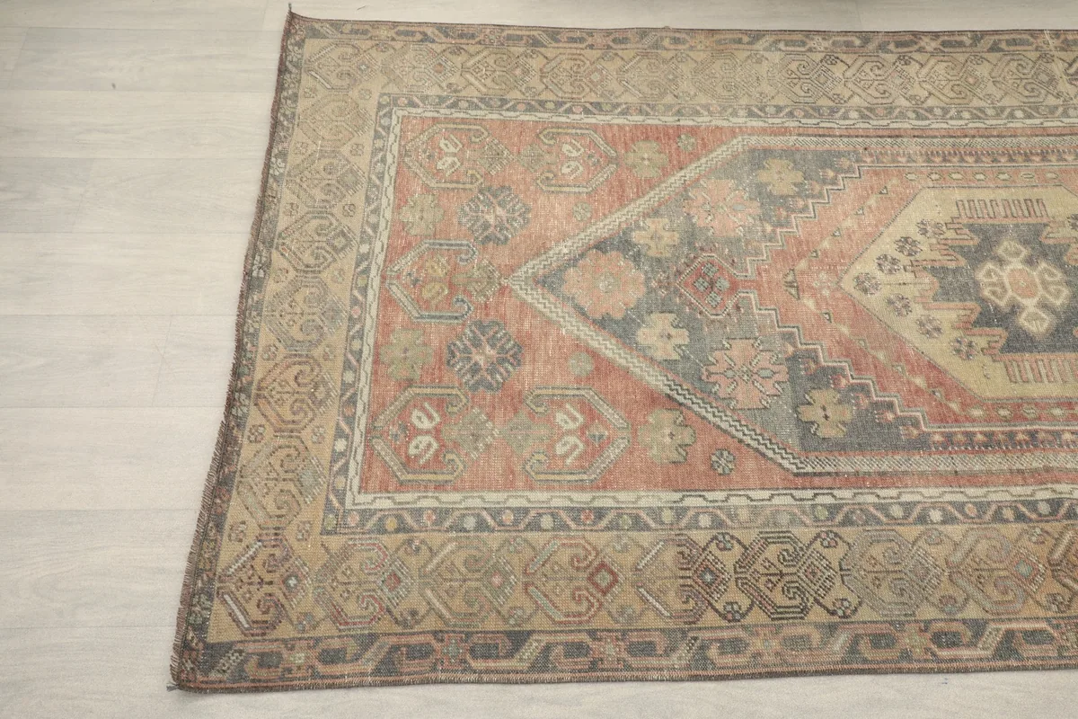 Angled view showing the subtle color variations and wear on the vintage wool rug