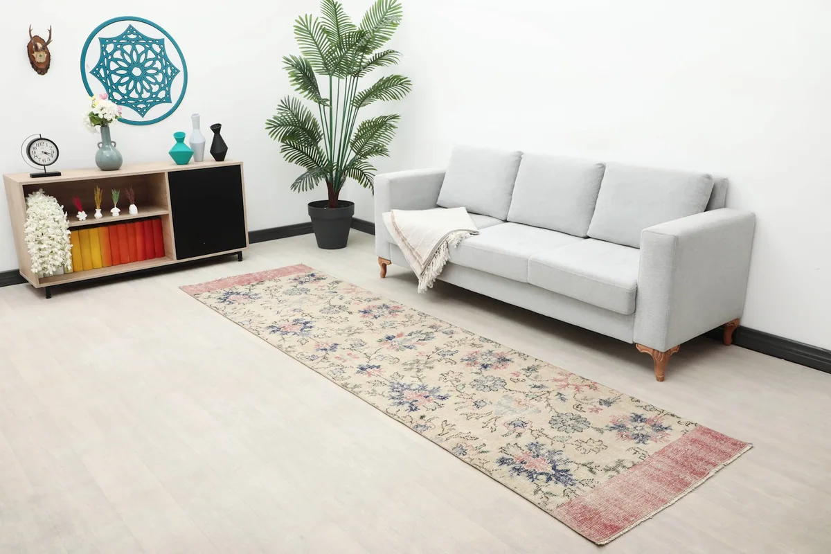 Long shot of the runner rug placed in a living room with a sofa and side cabinet.