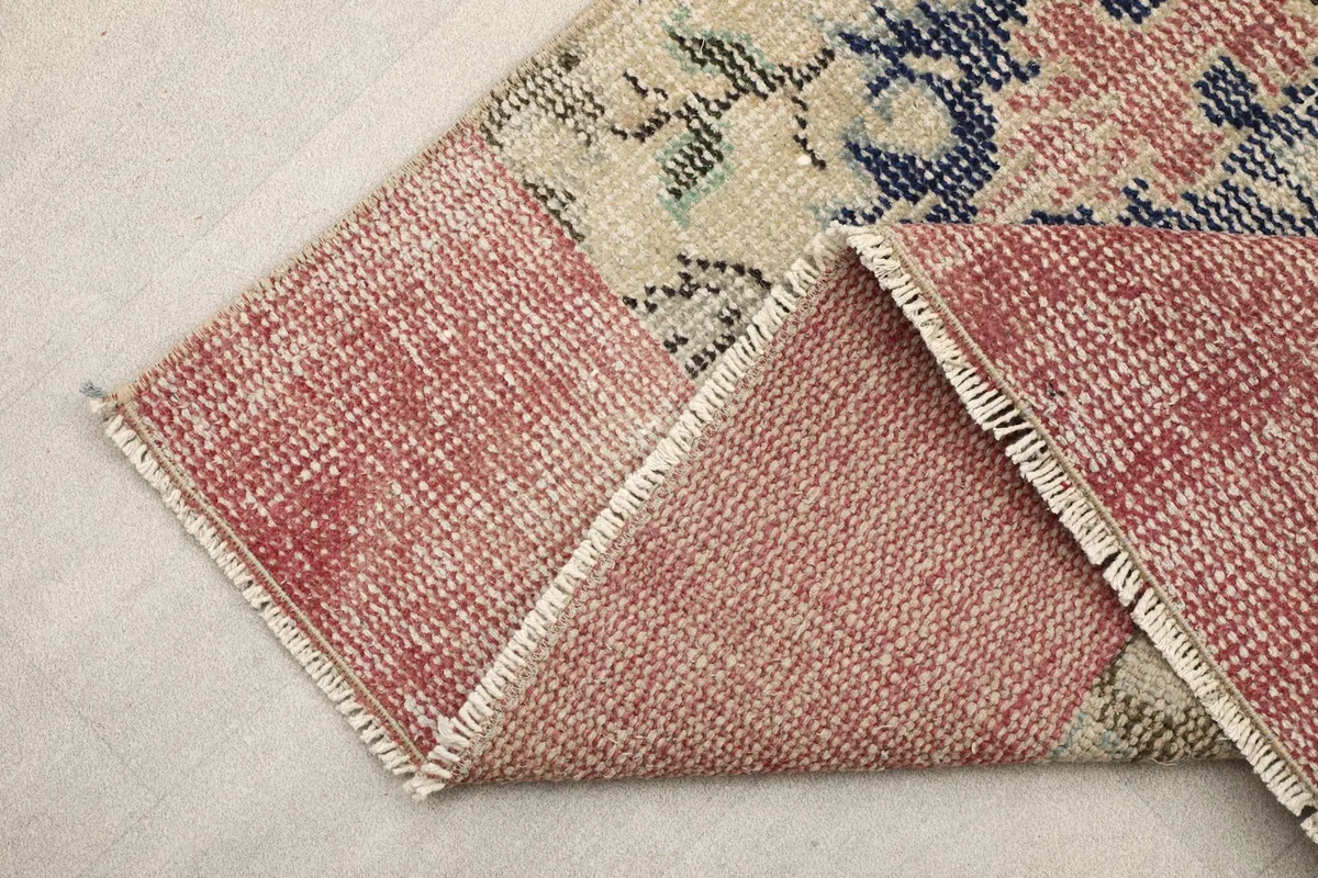 View of the back of the rug and the rose border, revealing the hand-knotted cotton foundation.