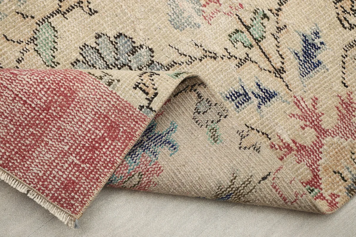 Folded section of the rug showing the wool pile and the cotton foundation underneath.