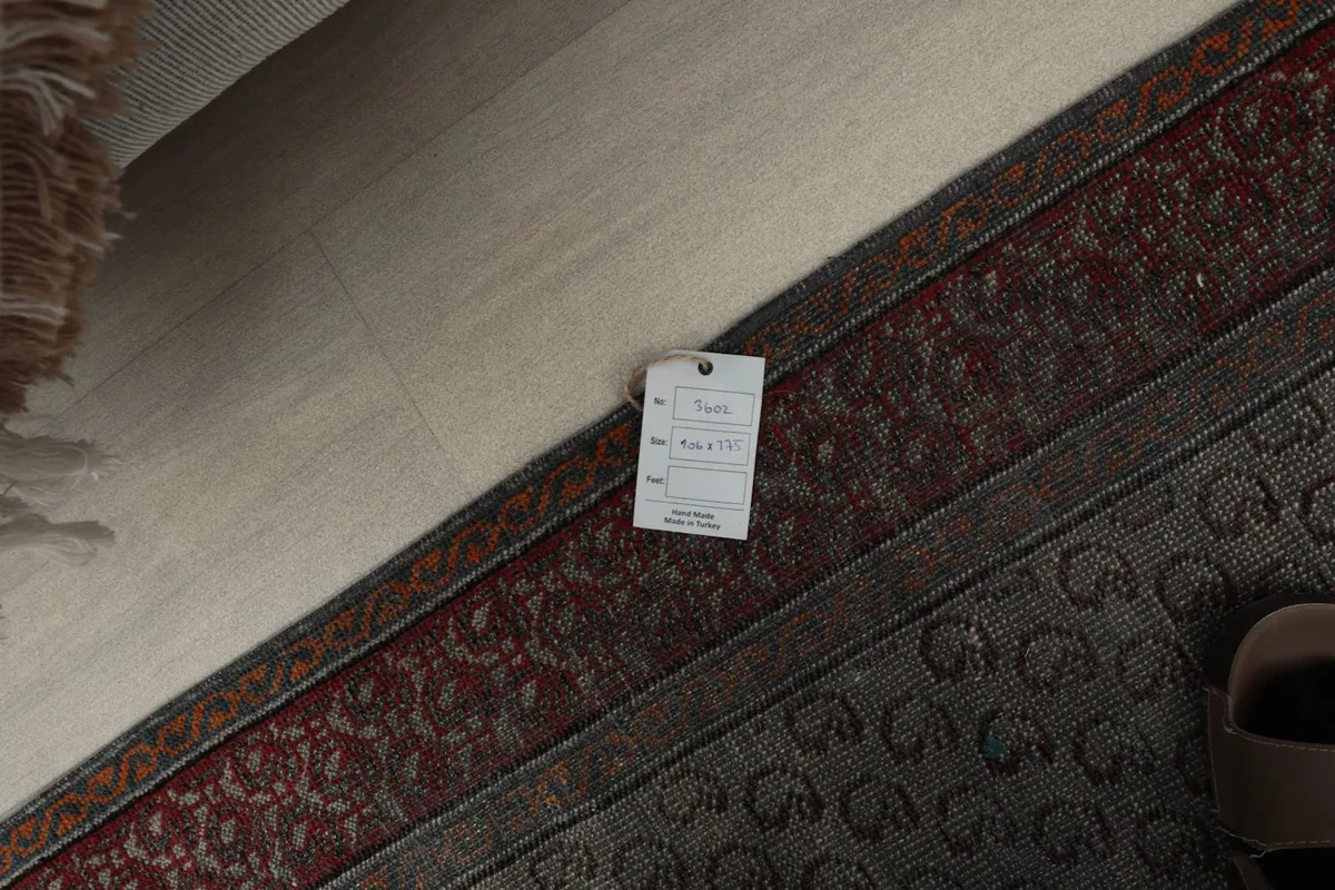 Close-up of the rug's edge with a product tag visible, showing details of the weave