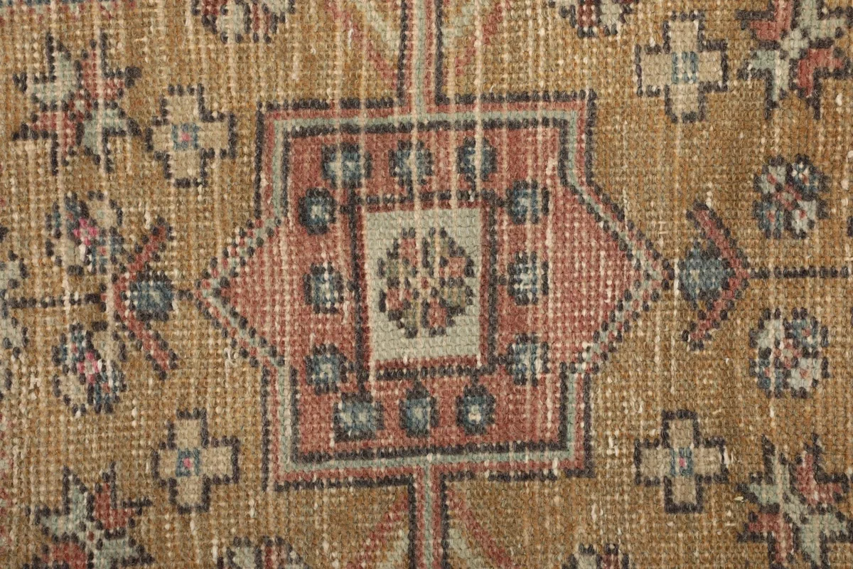 Close-up of the low wool pile, showing the hand-knotted texture and colors of the rug