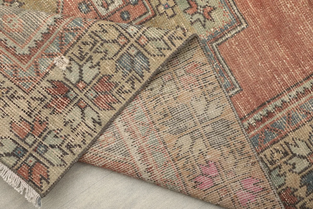 Folded corner of the rug revealing the reverse side and the tight knotting of the wool on cotton