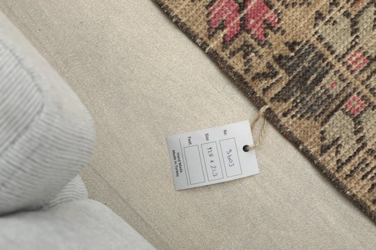 Product tag showing the rug's dimensions and origin, next to the rug on a light surface