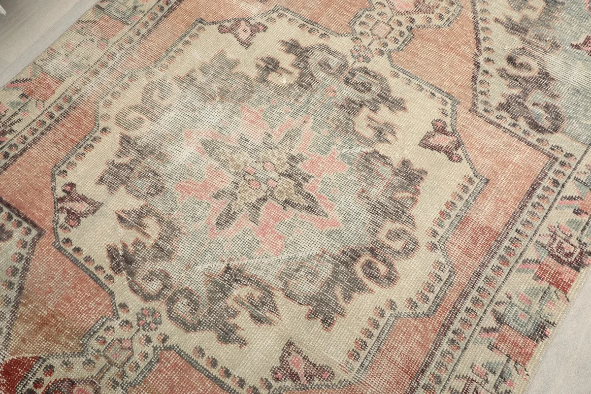Intricate detail of the central medallion pattern, revealing the hand-knotted texture and color variations