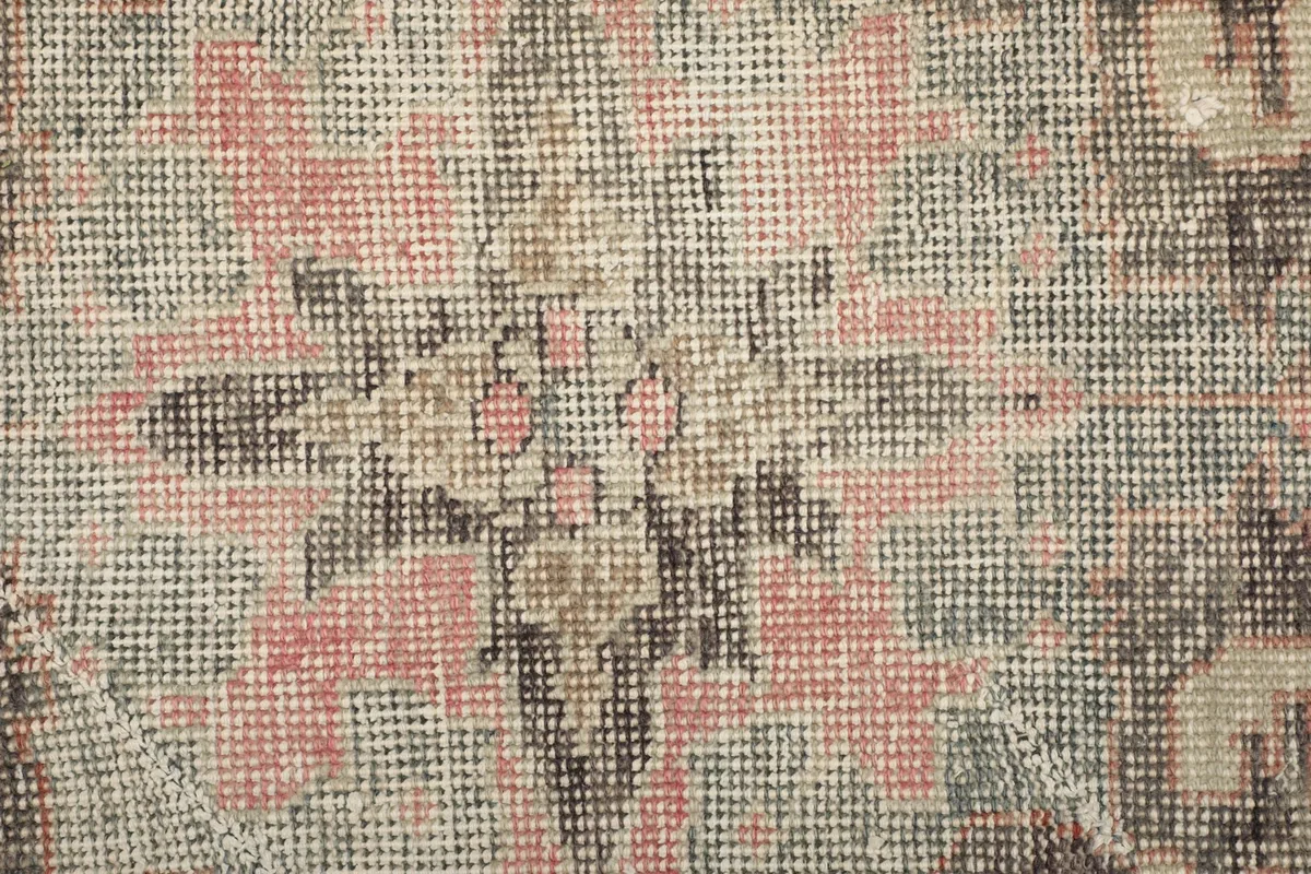 Extreme close-up of the rug's low wool pile, showing individual knots and color blend