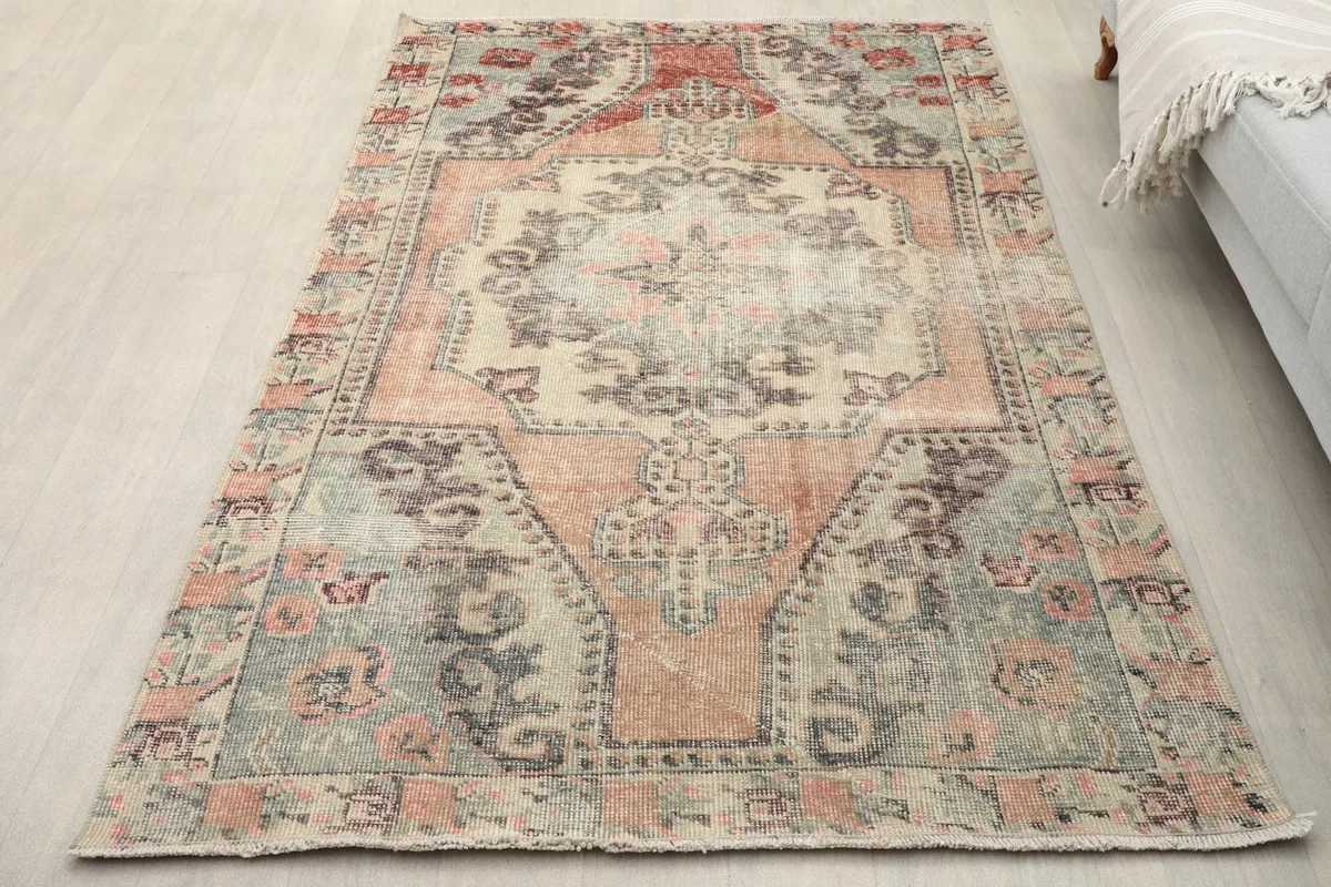 Overhead view of the vintage rug laid on a light floor, showing its full design and colors
