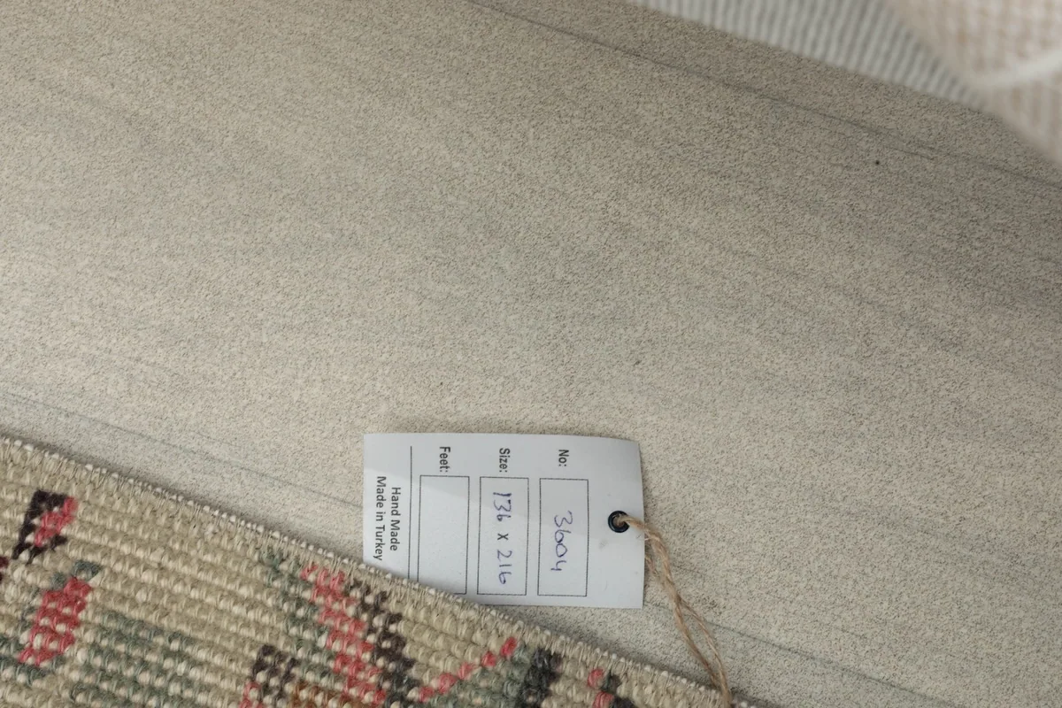 White tag attached to the rug, displaying its size in centimeters and product details