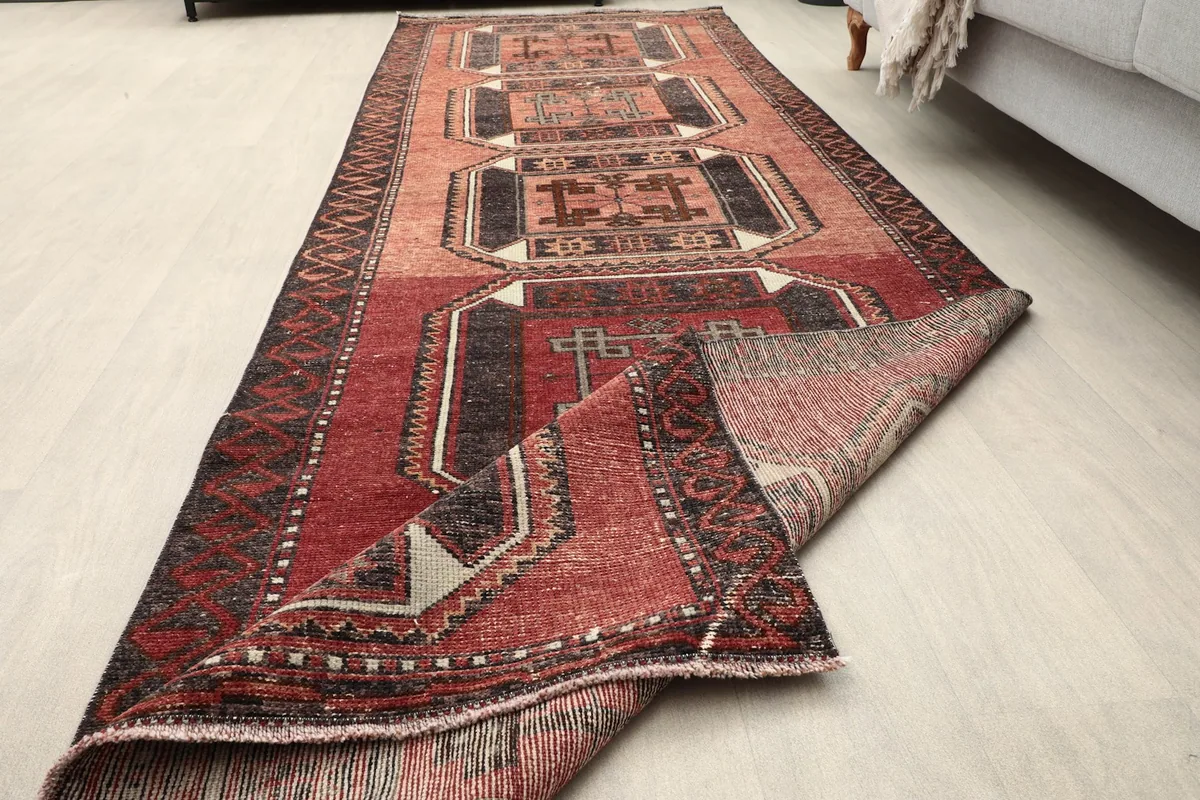 The vintage red runner partially folded, revealing the underside and structure.