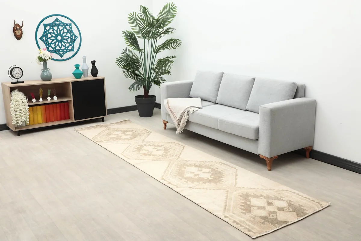 Wide shot of the ivory runner rug in a room setting with a sofa and console table