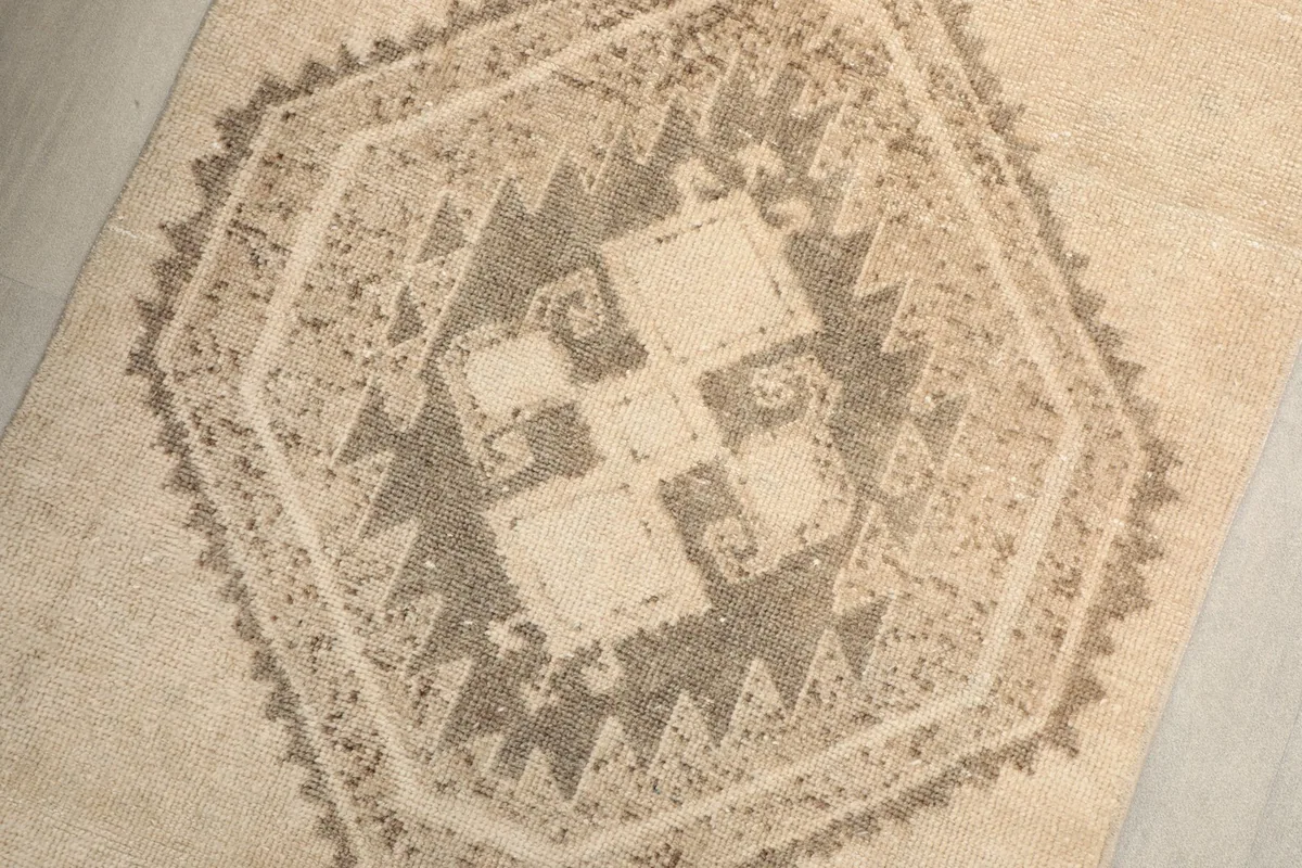 Overhead close-up of a central geometric medallion with ivory, beige, and brown tones