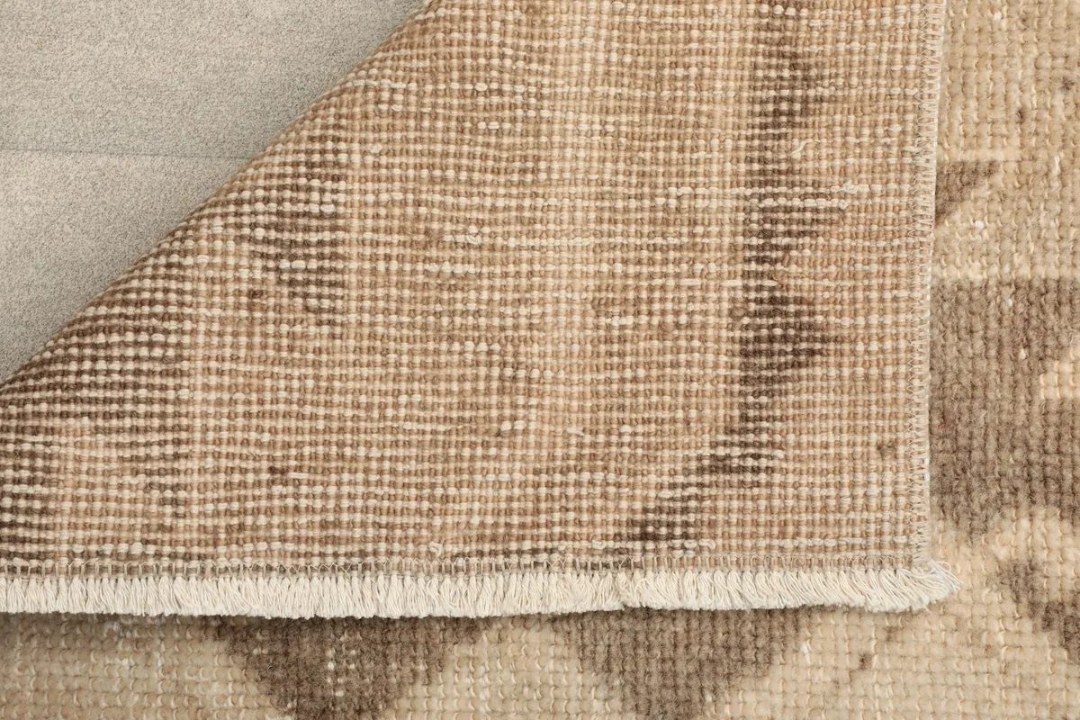 Underside of the rug showing the tightly woven cotton foundation and hand-knotted structure