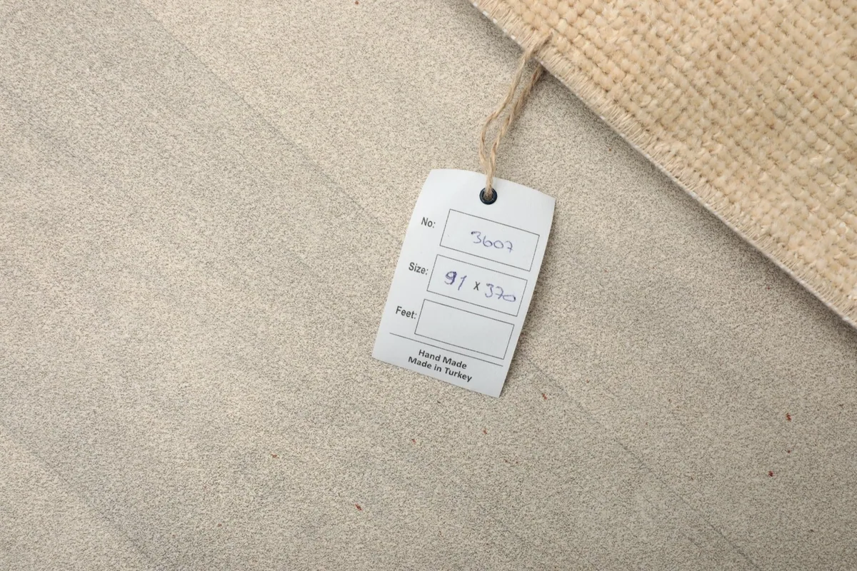 Close-up of a tag attached to the rug, displaying item number and size details