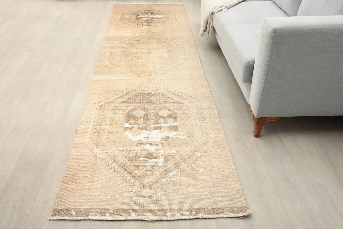 Angled view of the tan runner with geometric medallions in a room setting