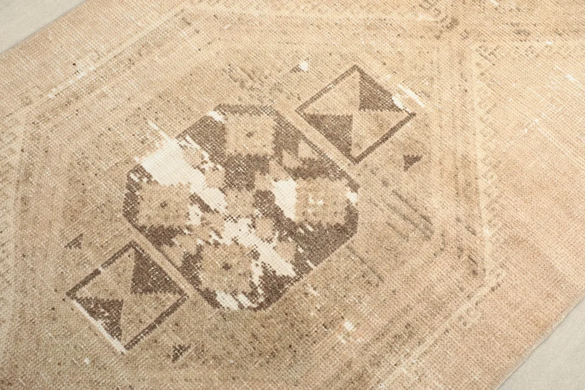 Extreme close-up of the central geometric motif with noticeable wear and tan base
