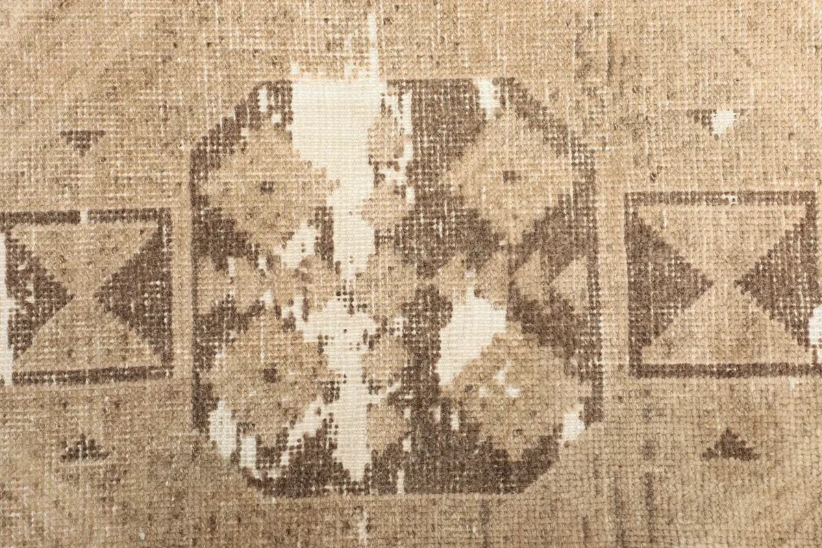 Macro view of the distressed wool pile and cotton foundation showing pattern details