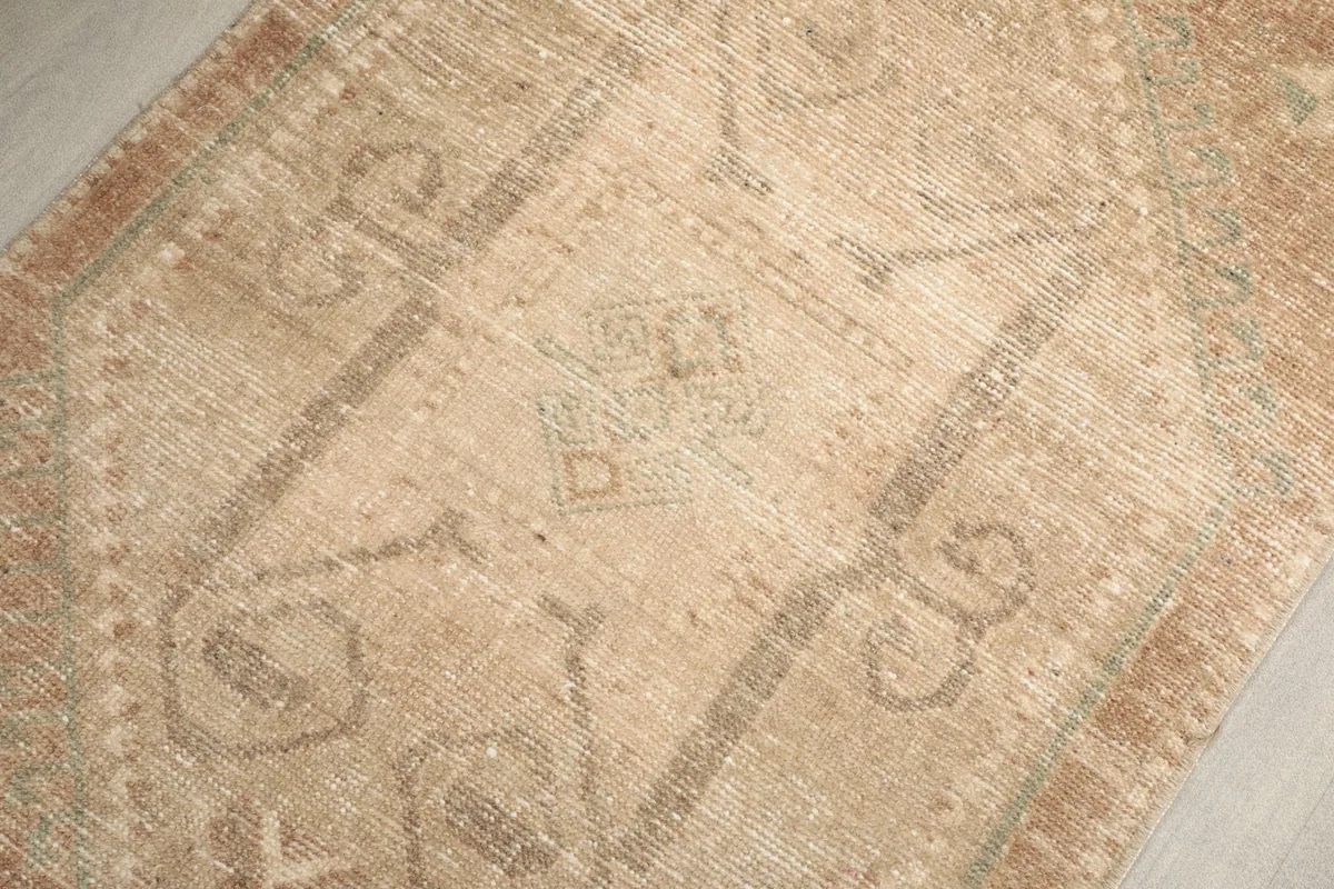 Detailed view of the intricate geometric and tribal patterns with subtle green and tan tones.