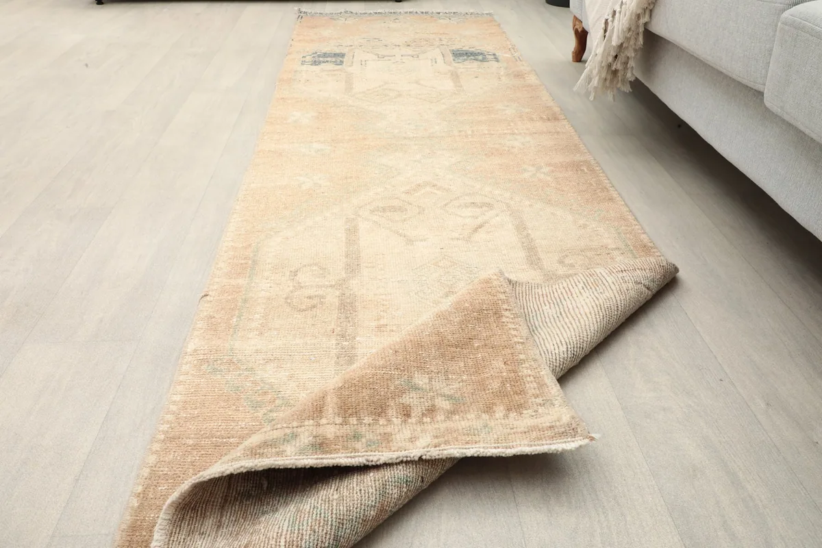 Runner rug with a corner folded over, showcasing the texture and its vintage character.