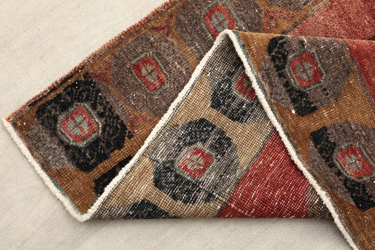 Folded corner of the runner, highlighting the border design and wool pile texture