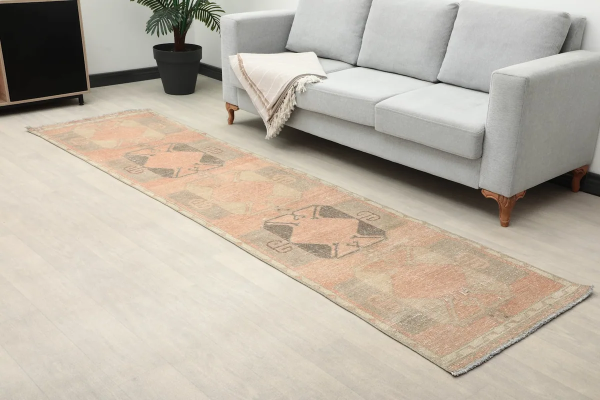 Long shot of the runner rug in a room with a sofa and a plant, highlighting its length and placement.