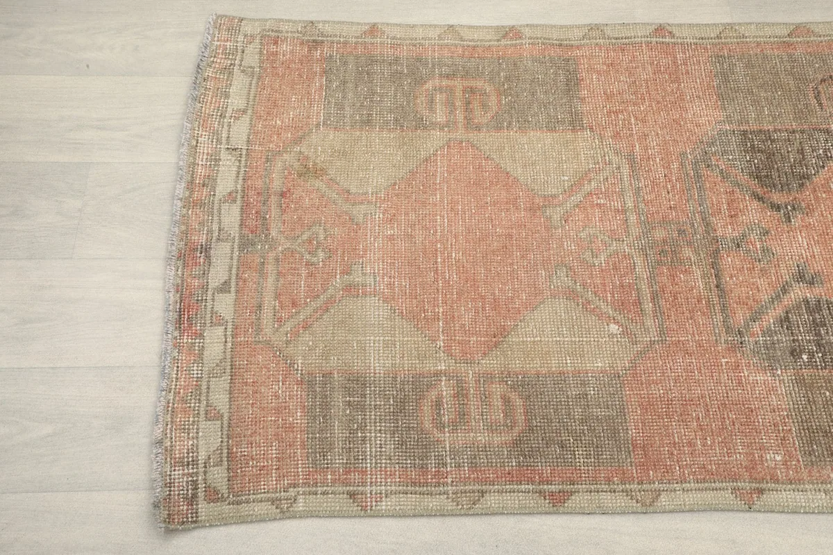 Detailed view of the rug's side border and geometric patterns, showing the color variations.