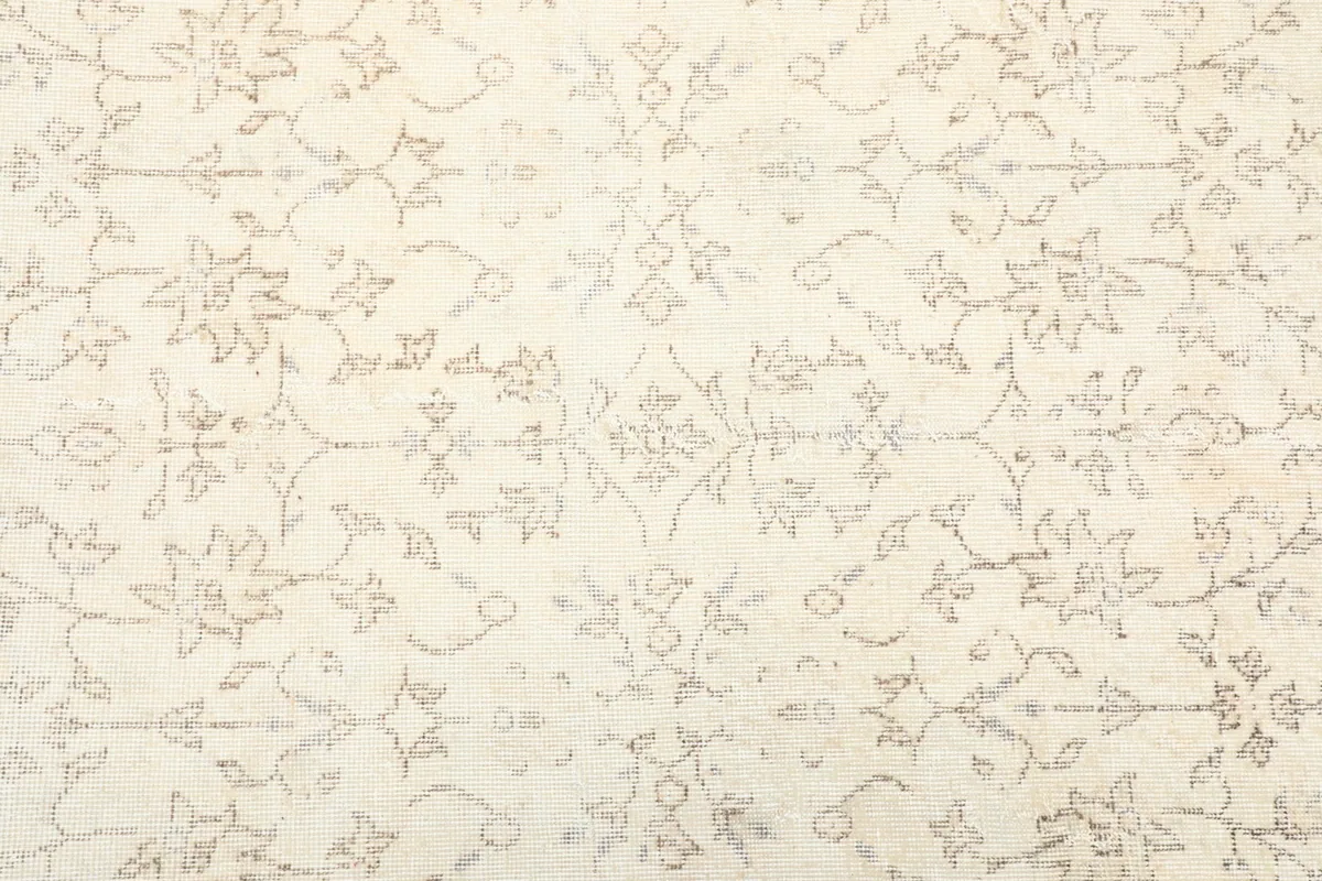 Detailed view of the central field pattern, showing faded botanical motifs