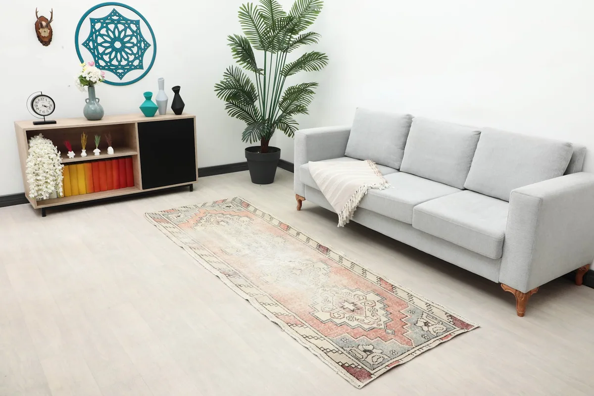 Long view of the rose runner in a modern living space with a sofa and shelving.