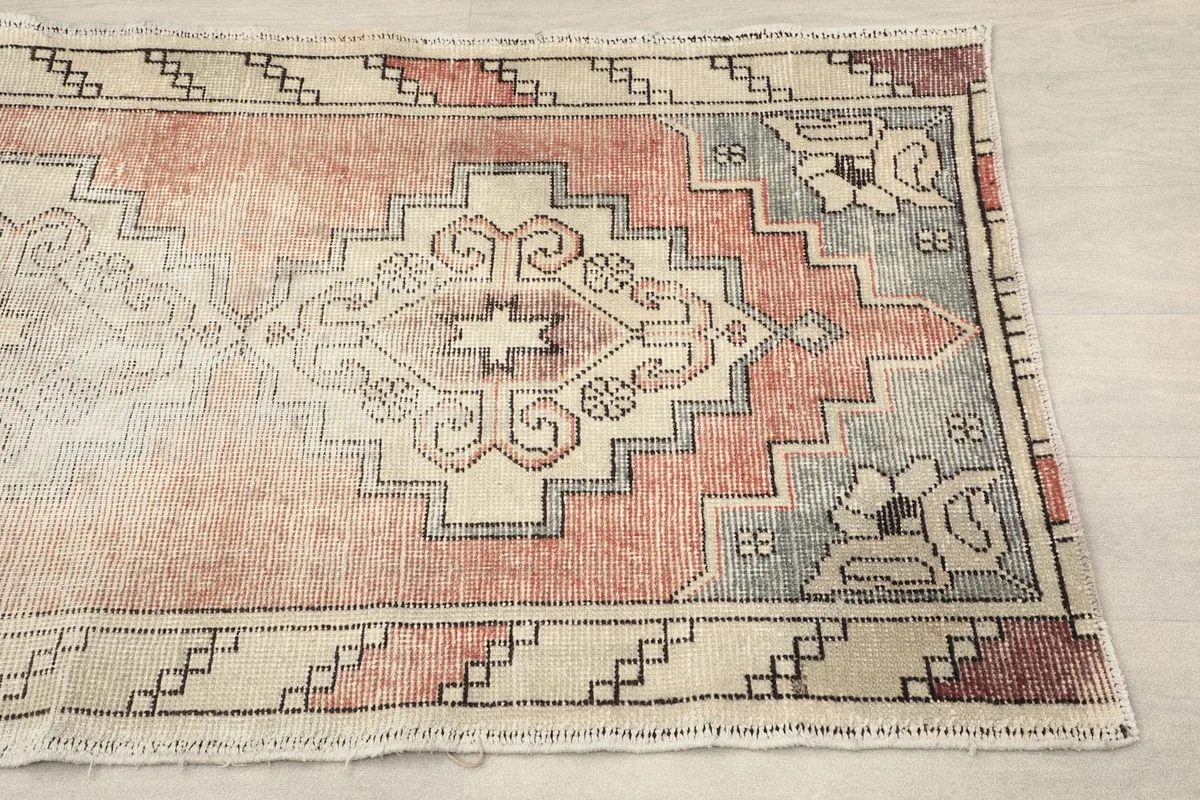 Close-up of the lower section of the runner, highlighting the rose, beige, and gray geometric patterns.