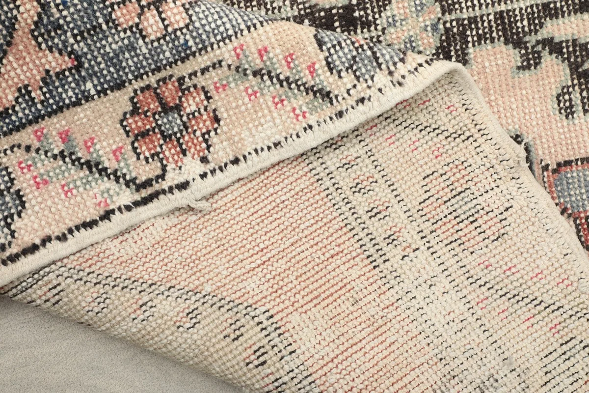 View of the back of the hand-knotted rug, showing the cotton foundation and tight weave