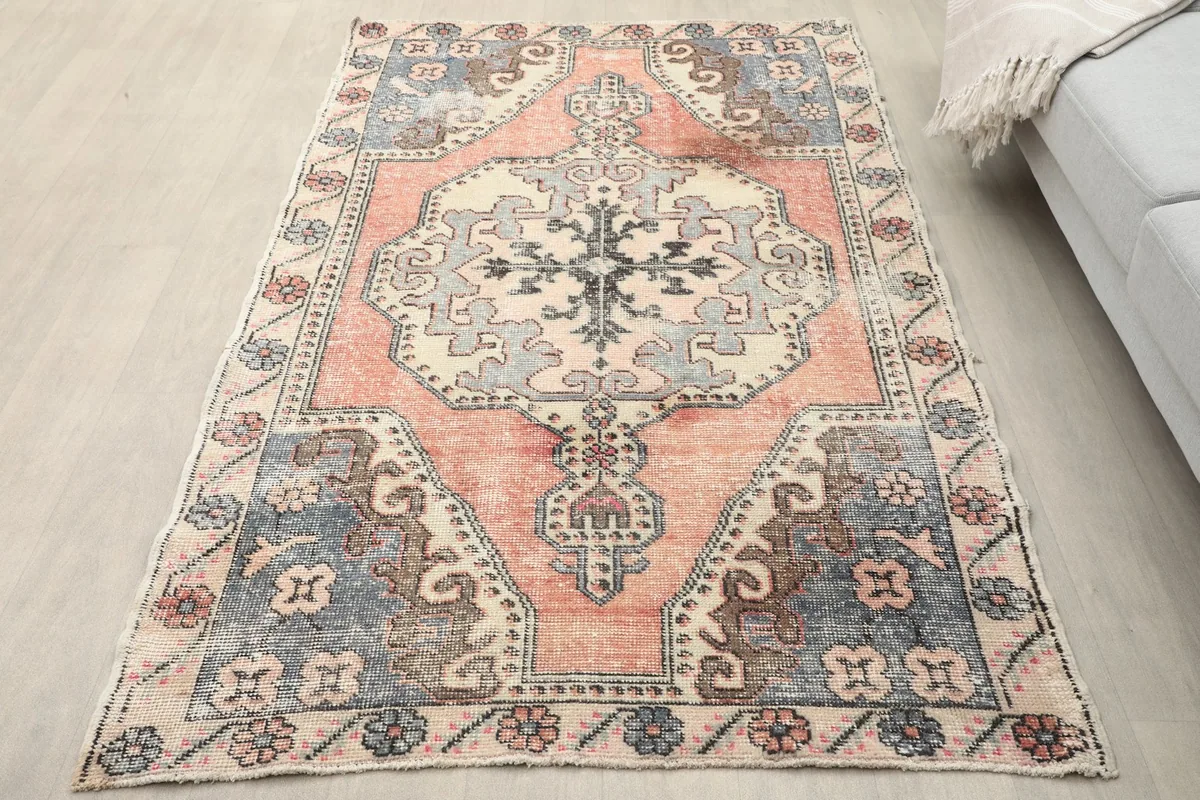 Overhead view of the rose and blue vintage rug in a room setting with light flooring