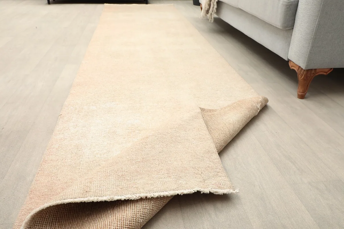 Angled view of the runner on the floor with one end slightly folded back.