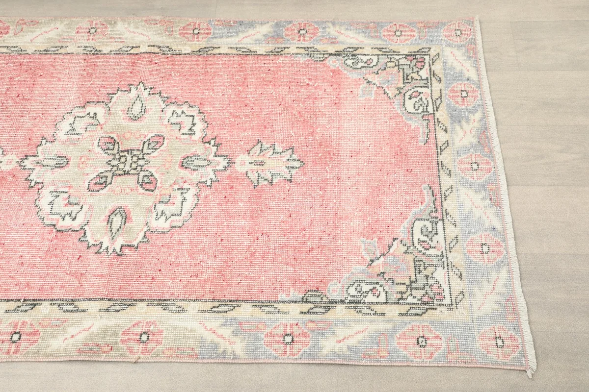 Close-up of the pink field and ivory medallion motif with gray border details