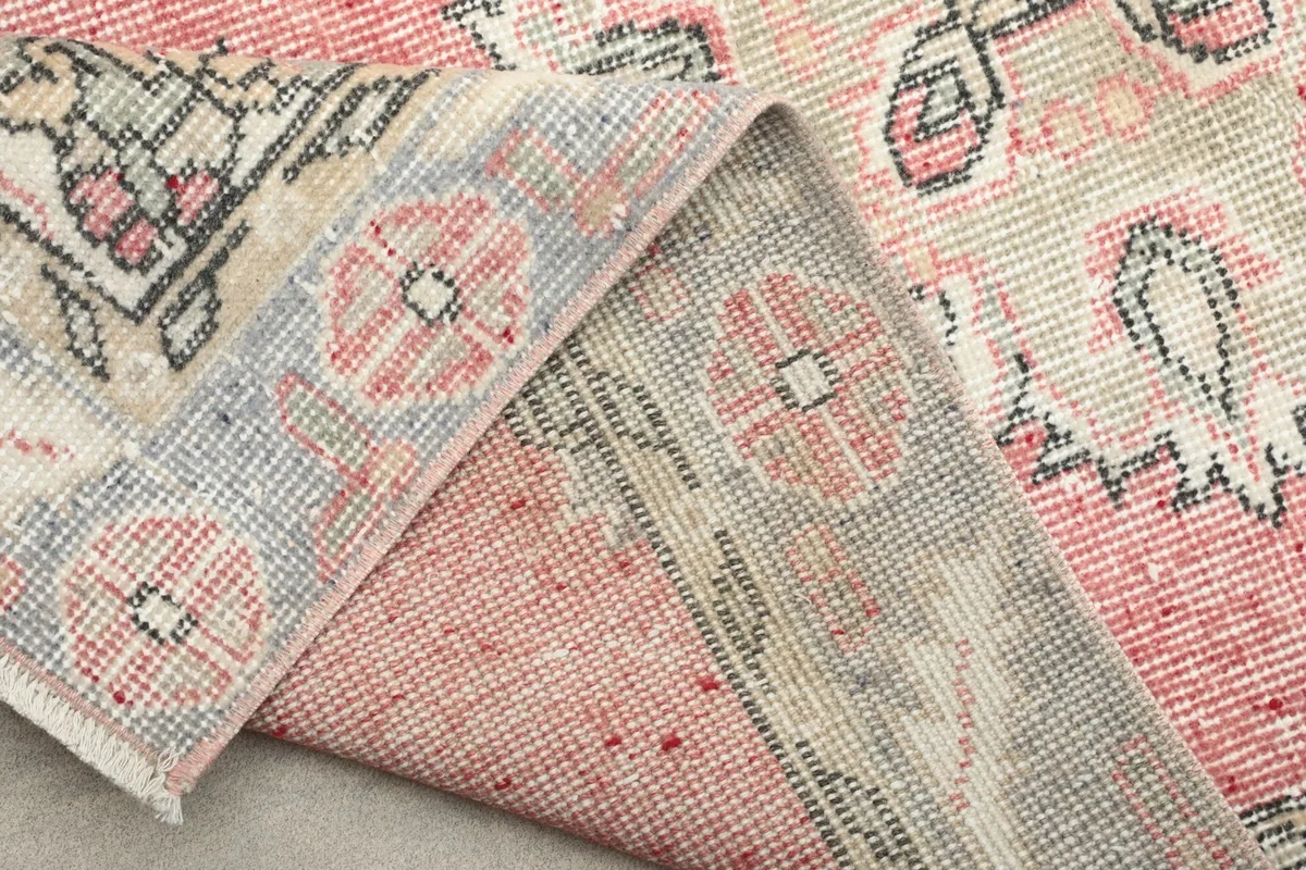 Partial view of the rug's back, showcasing the hand-knotted construction