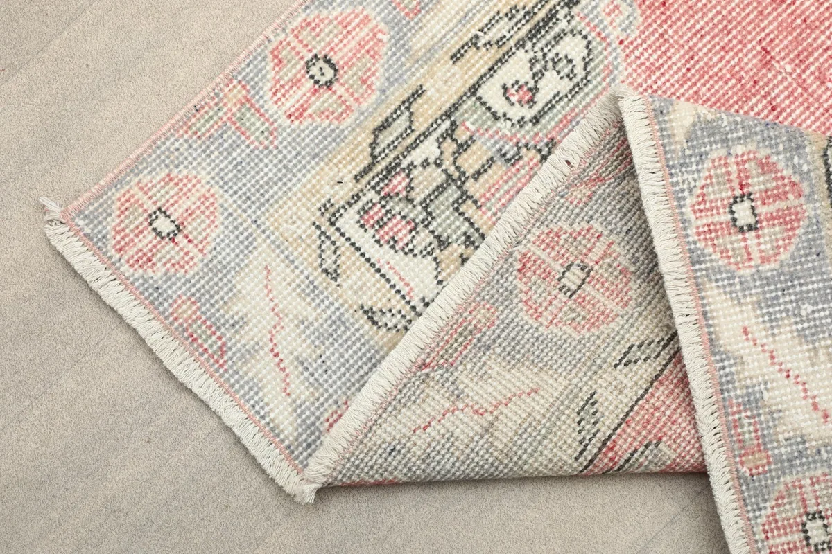 Folded corner of the rug revealing the cotton foundation and reverse side details