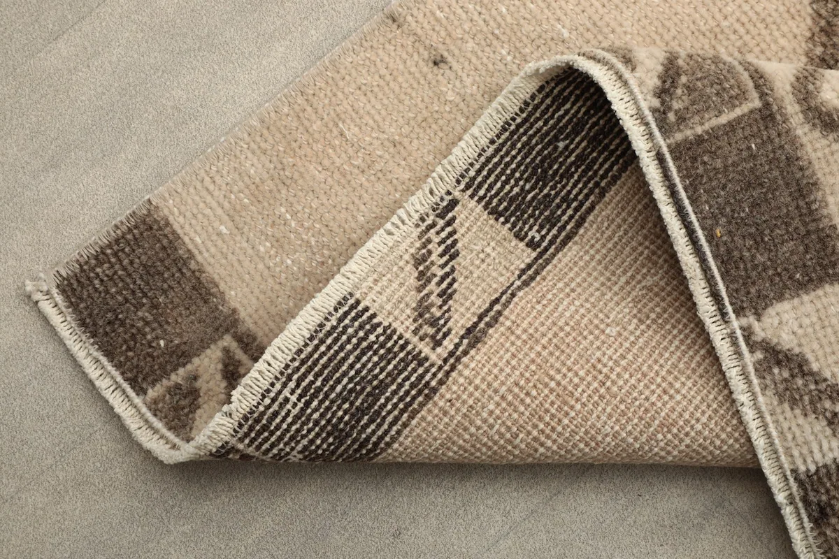 Folded corner showing the back of the hand-knotted wool pile on cotton foundation.