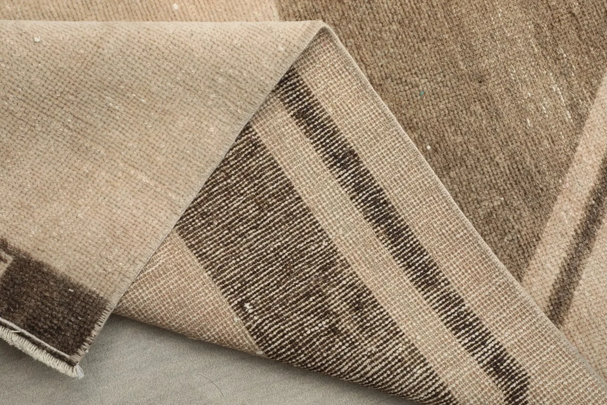 Underside view of the rug, revealing the woven cotton foundation and knotting.