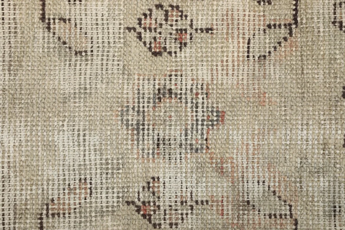 Macro view of the low wool pile, showing the individual knots and the subtle color shifts of the vintage rug.
