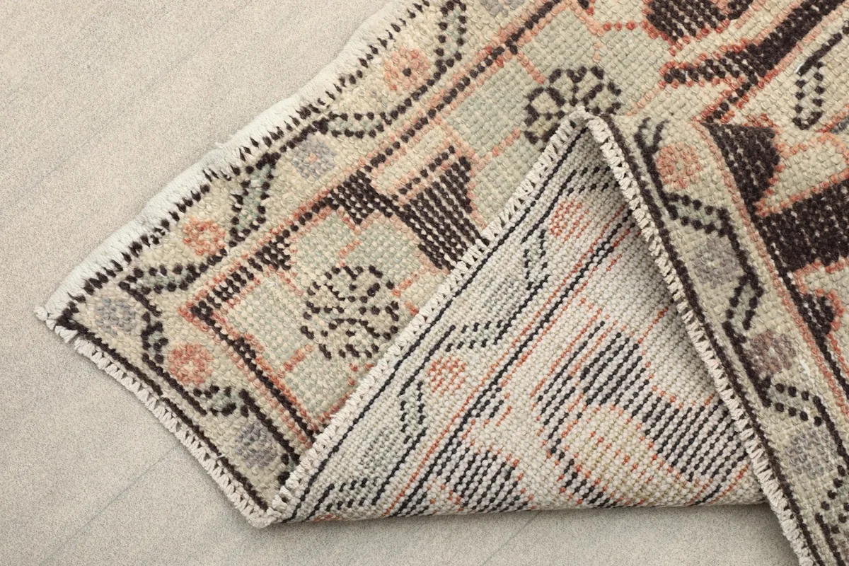 View of the rug's underside, revealing the cotton foundation and the reverse of the hand-knotted wool pile.