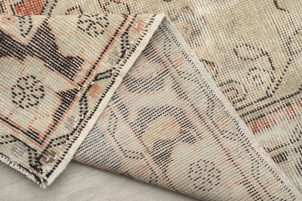 Another perspective of the rug's back, showcasing the tightly woven cotton foundation and craftsmanship.